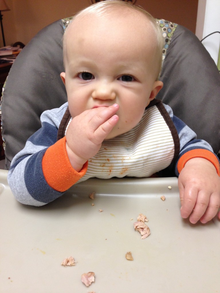 baby eating chicken sausage
